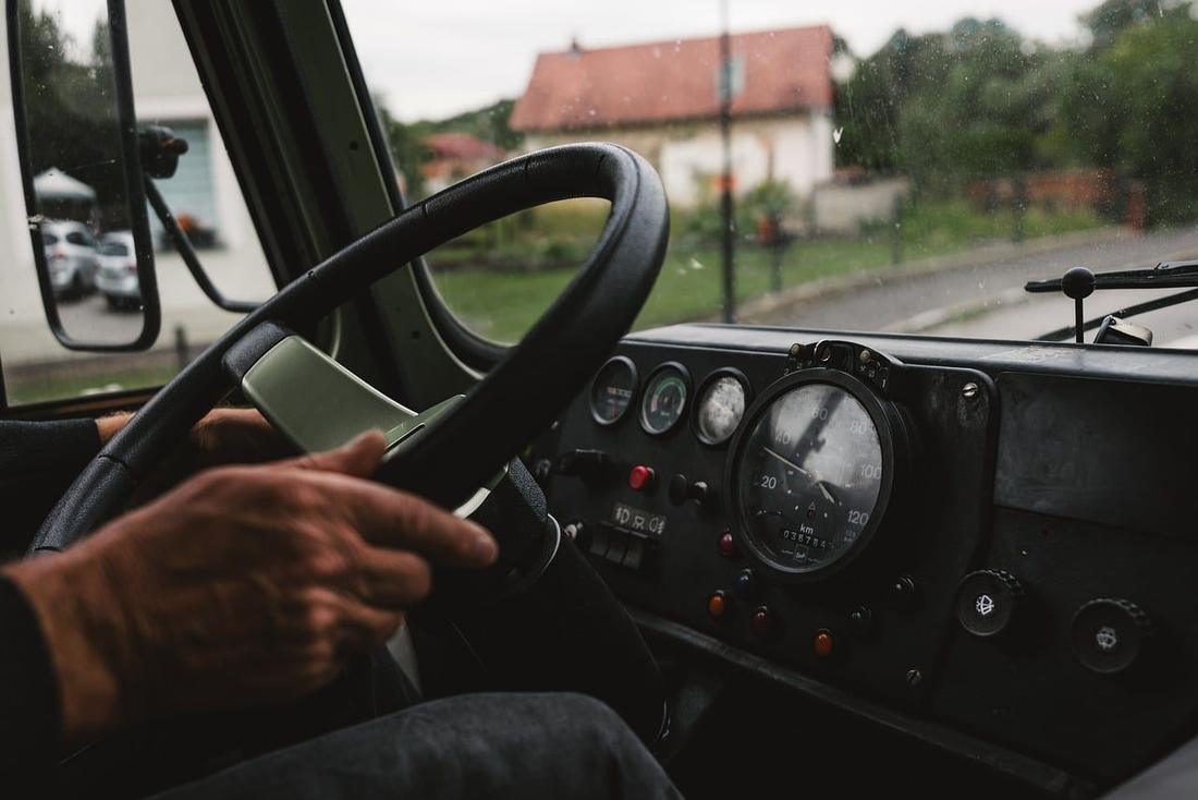 Dłonie na kierownicy autobusu, droga przez wieś