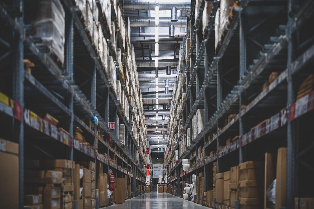 Aleja wysokich regałów w magazynie nocą